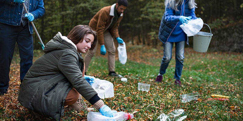 group-of-volunteers-cleaning-up-forest-from-waste