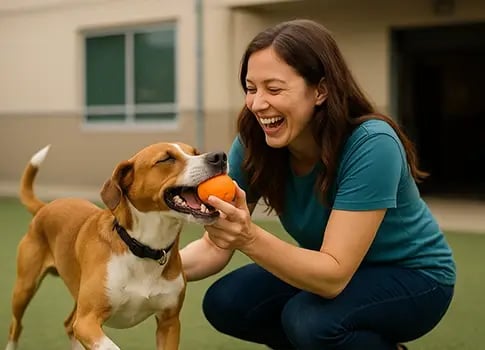 Woman happily playing with a rescue dog.