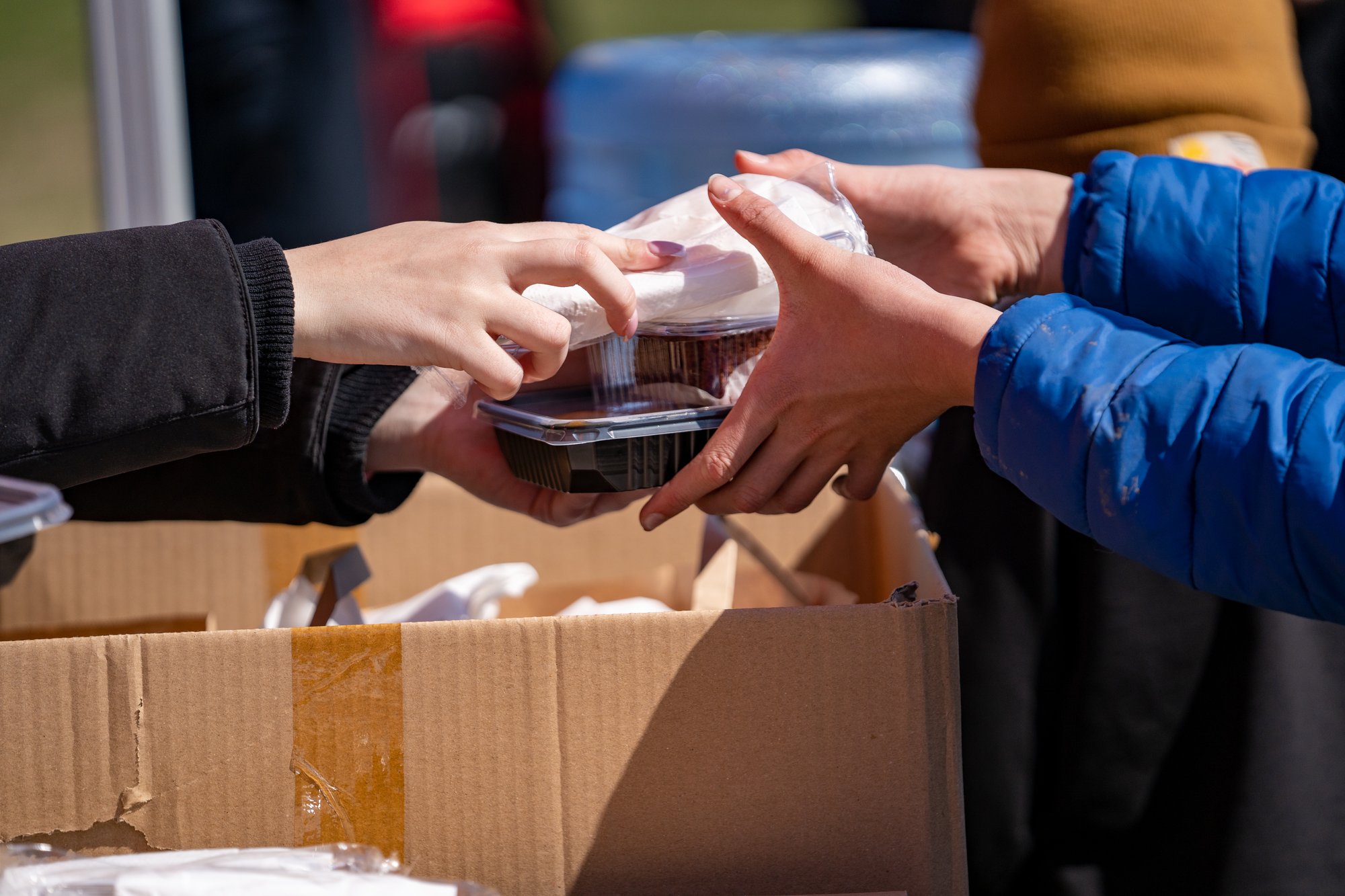 hands-passing-boxed-meal-during-charitable-food-di-2026-01-08-00-26-14-utc