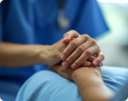 Close-up of a caregiver’s hands gently holding those of a patient, symbolizing comfort and support in hospice care.
