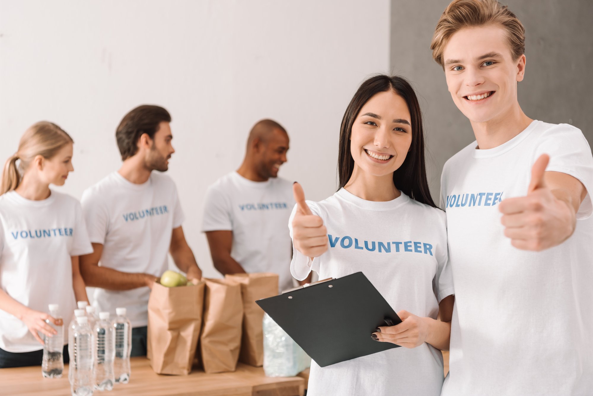 smiling-volunteers-packing-food-and-giving-thumbs-2026-03-12-23-53-27-utc