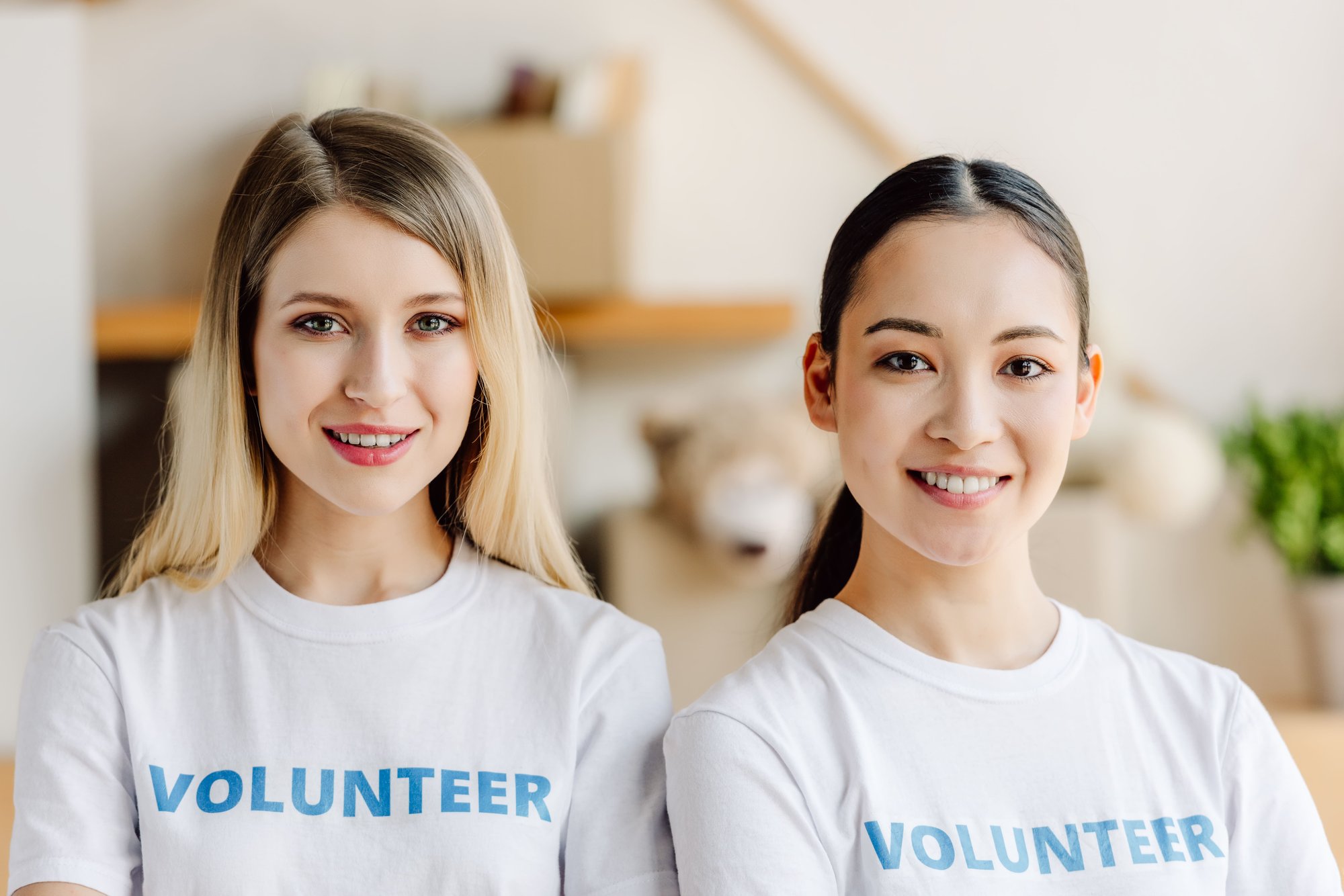 two-beautiful-multicultural-volunteers-in-white-t-2026-01-06-00-24-02-utc