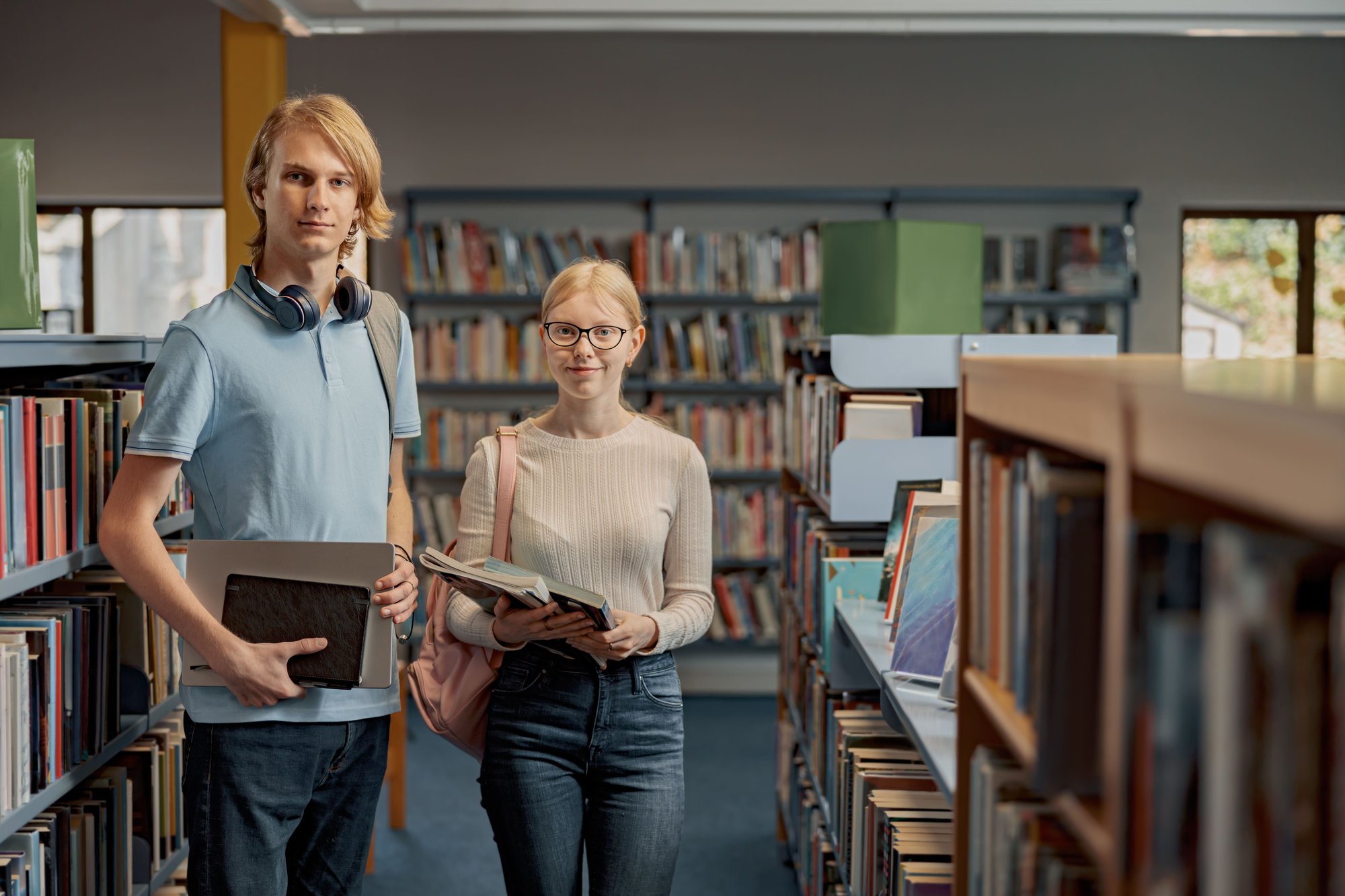 two-friends-student-chooses-books-while-standing-i-2026-03-20-02-08-43-utc